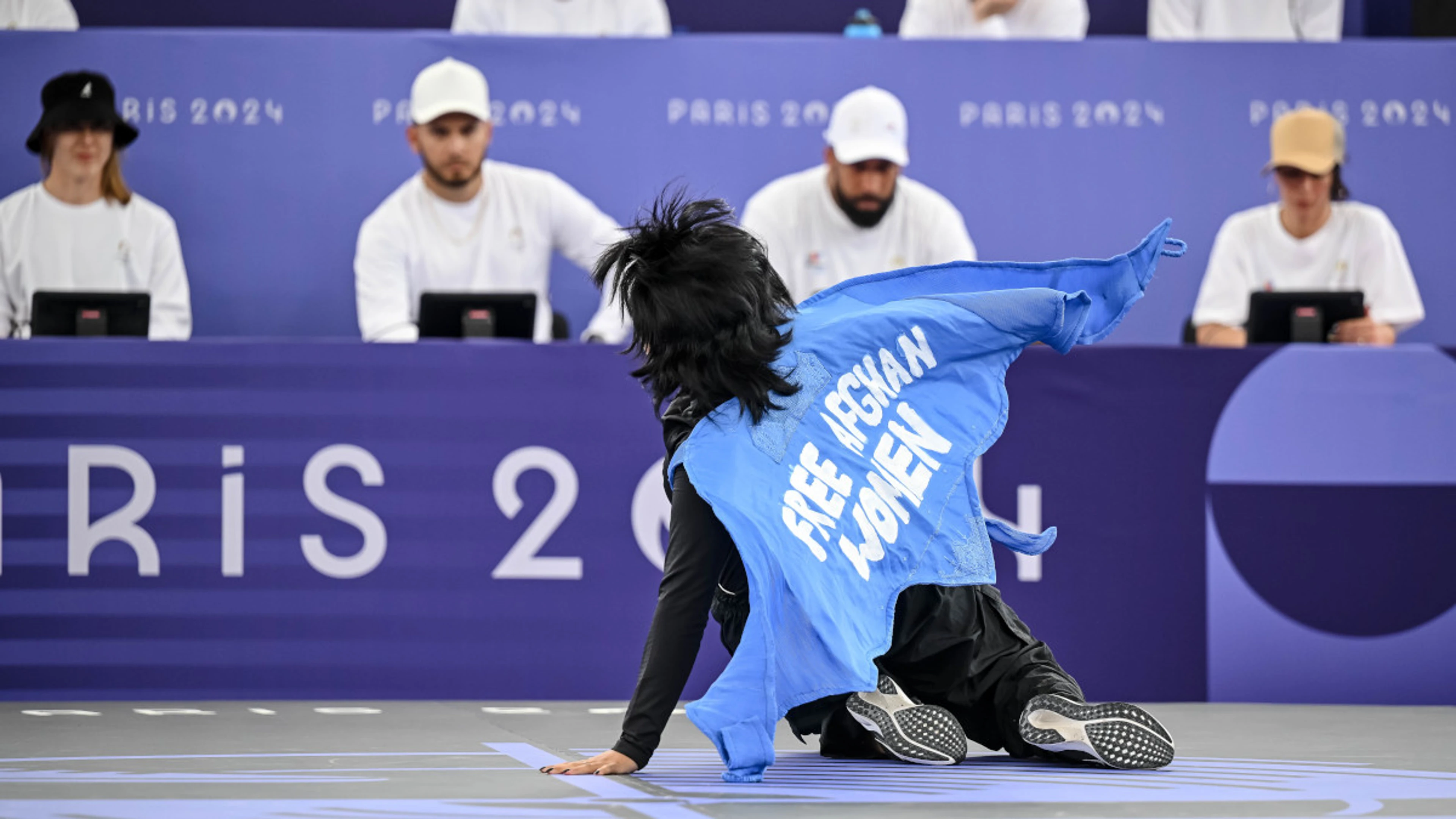 Afghan refugee athlete disqualified for slogan on cape